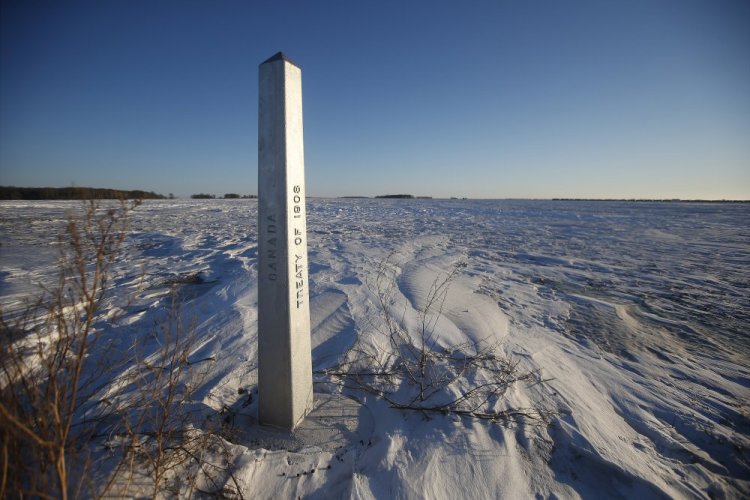 A marker at the border of the United States and Canada stands just outside Emerson, Manitoba, on Thursday. A Florida man was charged Thursday with human smuggling after the bodies of four people were found in Canada near the U.S. border, in what authorities believe was a failed crossing attempt during a freezing blizzard.