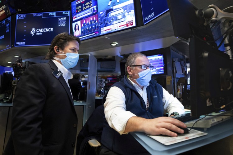 Trader Michael Conlon, right, works on the floor on Tuesday at the New York Stock Exchange. 