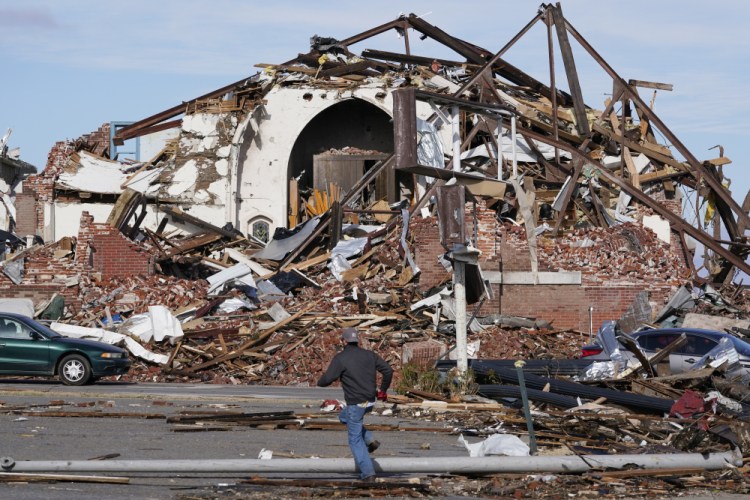 People survey damage from a tornado is seen in Mayfield, Ky., on Saturday, Dec. 11, 2021. 