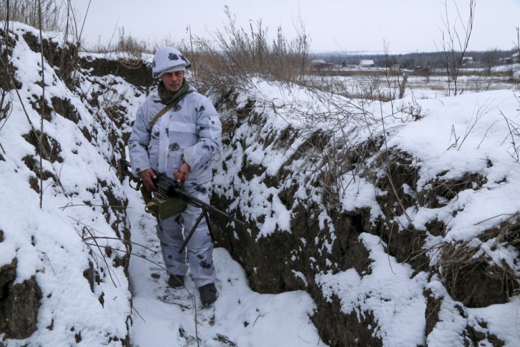 A serviceman stands holding his gun in a trench on the territory controlled by pro-Russian militants at the front line with Ukrainian government forces in Slavyanoserbsk, Luhansk region, eastern Ukraine, on Tuesday. 