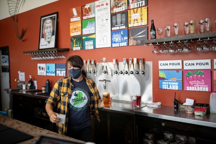 PORTLAND, ME - SEPTEMBER 13: Julia Starr pours beer for customer behind the bar at Rising Tide in Portland on Sunday, September 13, 2020. Rising Tide has, for a number of years, held a restaurant license that would allow indoor operations under strict occupancy limits, but owner Heather Sanborn said she will continue to operate outside due to safety concerns for her staff and customers. ÒThe plan is really to stay out here all year long and to just pivot and adjust as the weather throws us challenges,Ó Sanborn said. (Staff photo by Brianna Soukup/Staff Photographer)