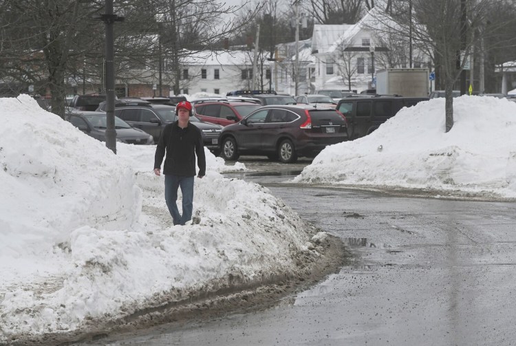 A man walks on a sidewalk Wednesday along the Concourse in downtown Waterville. The city this year is clearing snow from sidewalks downtown on a trial basis to determine the value and cost of continuing to do so into the future.