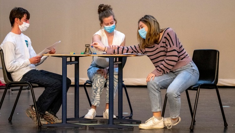 Samuel Goldy, left, Brianna Harriman and Grace Kirk, right, run through a comedy skit during Chizzle Wizzle rehearsal Thursday in the auditorium at Cony Middle and High School in Augusta. On Wednesday Chizzle Wizzle President Kirk asked the Board of Education to consider lifting the mask mandate for on-stage performers during the production.