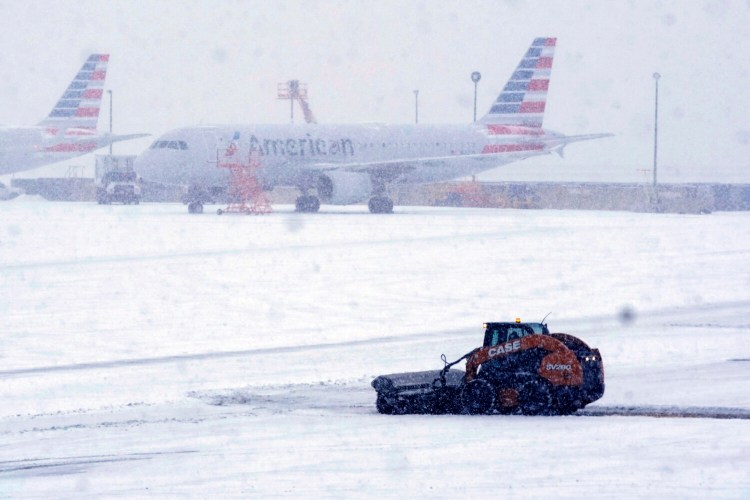 Snow and ice are cleared from the tarmac at Dallas Fort Worth International Airport in Grapevine, Texas, Thursday, Feb. 3, 2022. A major winter storm with millions of Americans in its path is spreading rain, freezing rain and heavy snow further across the country. (AP Photo/LM Otero)