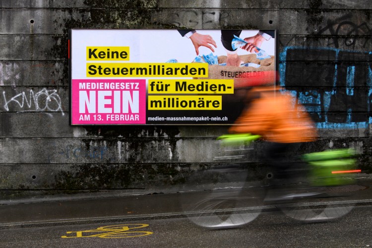 A poster reading 'No tax billions for media millionaires. Media Law No' displayed on a wall in Bern, Switzerland, Wednesday, Feb. 2022. On Sunday, Feb. 13, 2022, voters in Switzerland consider on a government's public aid plan to support broadcast and print media. (Anthony Anex/Keystone via AP)