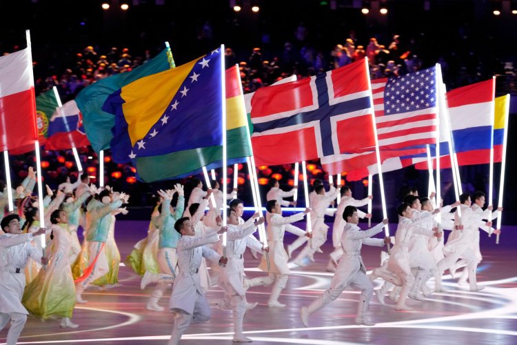 Performers carry flags during the closing ceremony of the 2022 Winter Olympics in Beijing on Sunday.