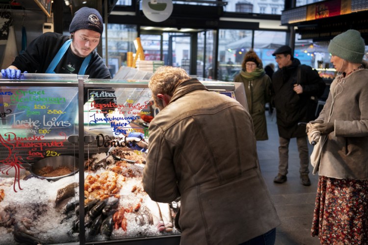 Customers shop at the fish market in Torvehallerne in Copenhagen, Denmark, on Tuesday. Starting Tuesday, it was no longer mandatory to wear protection masks anywhere in public in Denmark.