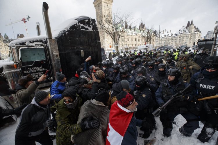 Police move in to clear downtown Ottawa near Parliament Hill of protesters on Saturday. 

