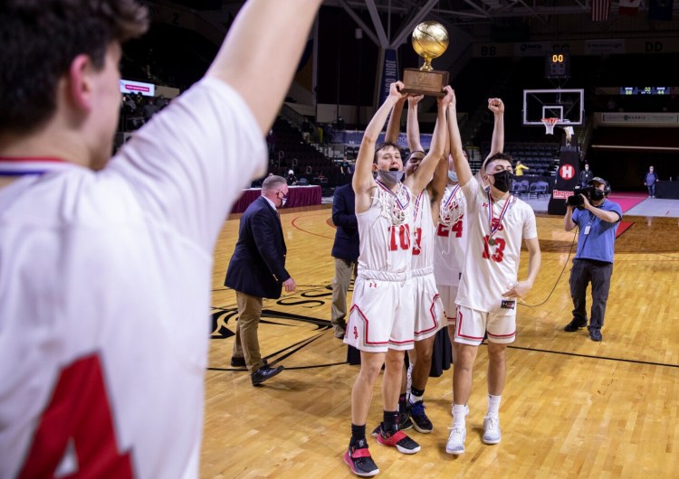 South Portland boys basketball players celebrate with their trophy after beating Oxford Hills in the Class AA state championship game on Saturday.
