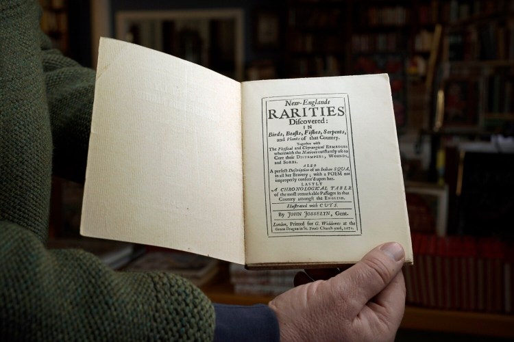 Don Lindgren of Rabelais Books holds open his copy of a 1926 facisimile of "New-Englands Rarities Discovered."
