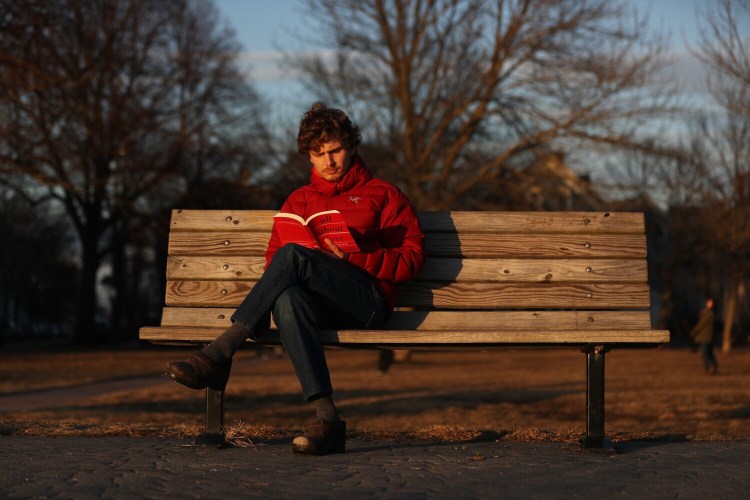 Robby Lewis-Nash of Portland reads a book in the dwindling sunlight at Ft. Sumner Park on Wednesday. The U.S. Senate voted on Tuesday in favor of making daylight saving time permanent. Lewis-Nash said he supported the proposal. 