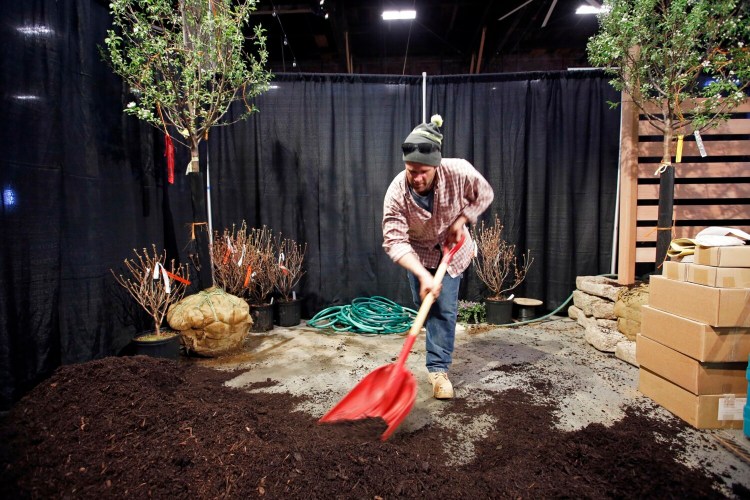 Peter Janas, a mason and landscaper, shoveled mulch around crabapple trees in preparation for the 2019 Maine Flower Show. This year, the Maine Garden + Marketplace will have no display gardens but will have some 100 booths showcasing vendors and nonprofit gardening and nature organizations.