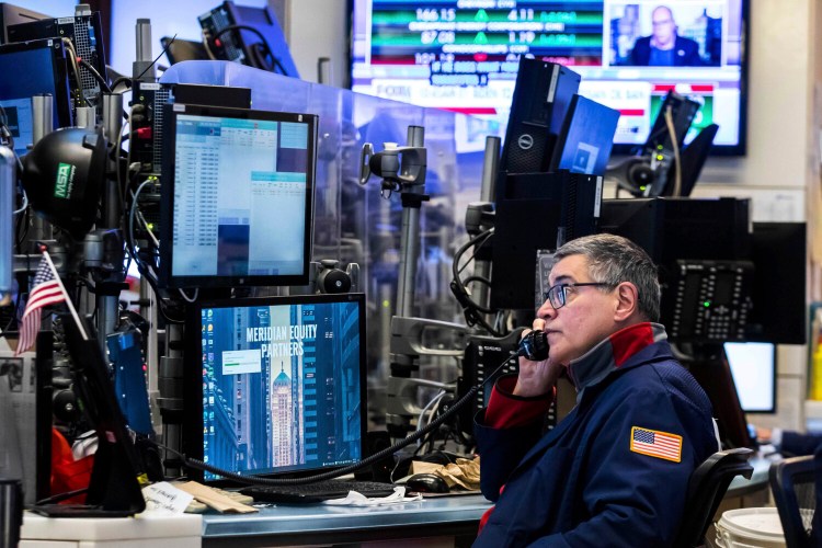 In this photo provided by the New York Stock Exchange, a trader works on the floor, Tuesday, March 8, 2022. Stocks yo-yoed, oil prices climbed and the price of nickel surged so much that trading for it was shut on Tuesday, as the U.S. banned imports of oil from Russia and the economic fallout from its invasion of Ukraine kept rocking markets. (Courtney Crow/New York Stock Exchange via AP)