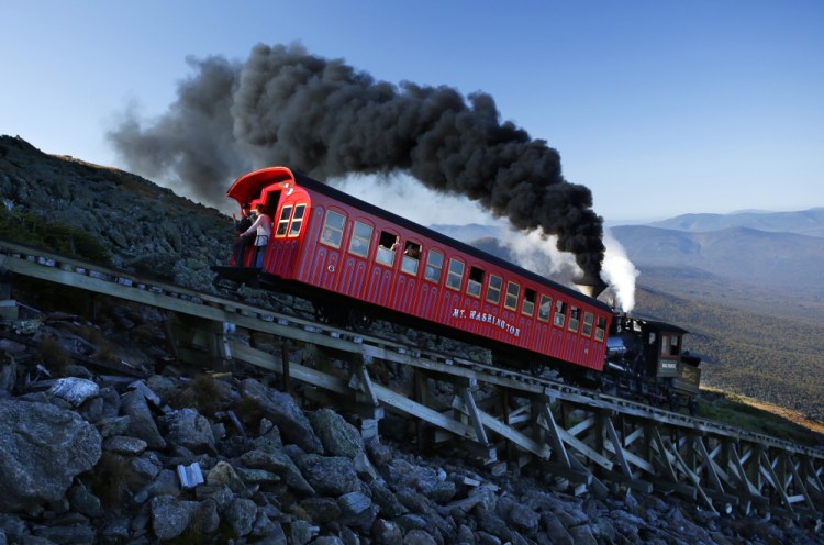 A vintage coal-fired steam engine pushes a passenger car up the Cog Railway on a 3.8-mile journey to the summit of 6,288-foot Mount Washington in New Hampshire.