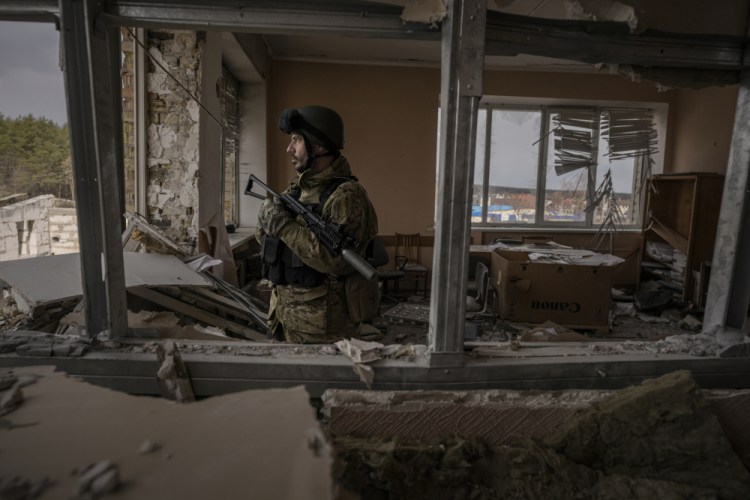 A Ukrainian serviceman stands in a heavily damaged building in Stoyanka, Ukraine on Sunday. 