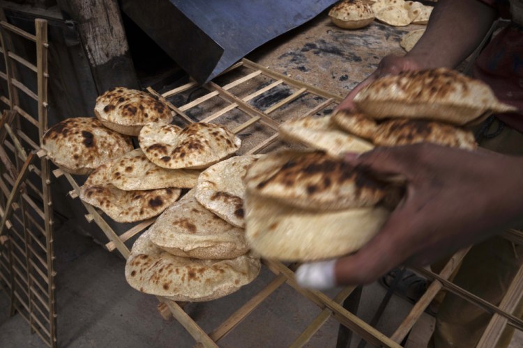 A worker collects Egyptian traditional 'baladi' flatbread, at a bakery Wednesday in el-Sharabia, Shubra district, Cairo, Egypt. The Russian tanks and missiles besieging Ukraine also are threatening the food supply and livelihoods of people in Europe, Africa and Asia who rely on the vast, fertile farmlands of the Black Sea region. That could create food insecurity and throw more people into poverty in places like Egypt and Lebanon, where diets are dominated by government-subsidized bread. 