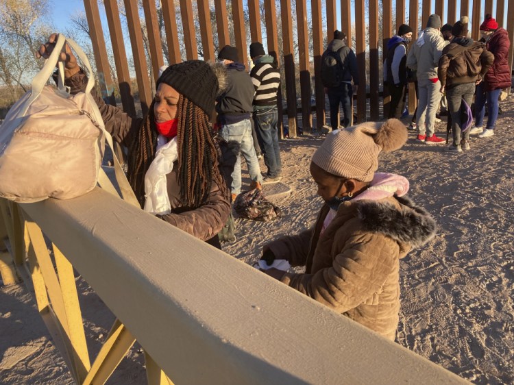 A Cuban woman and her daughter wait in line to be escorted to a Border Patrol van for processing in Yuma, Ariz., hoping to remain in the United States to seek asylum.