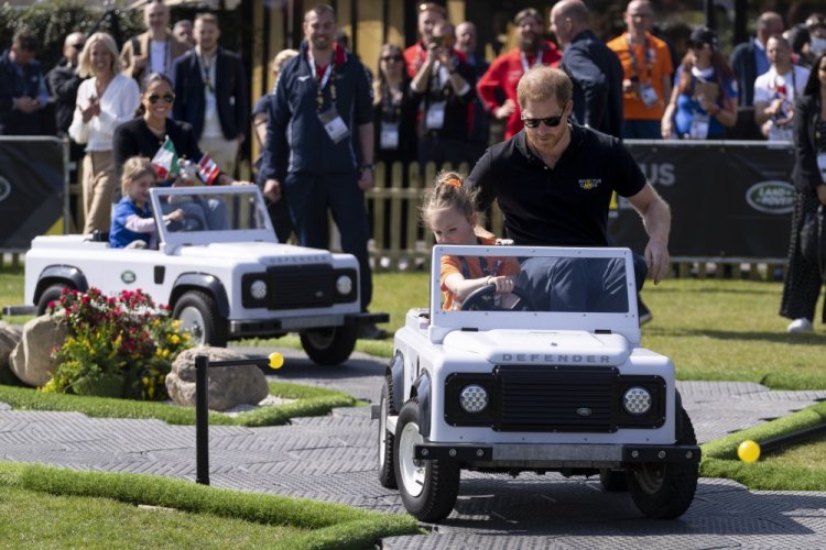 Prince Harry, right, and Meghan Markle, rear left, the duke and duchess of Sussex, take part in the Land Rover Driving Challenge at the Invictus Games venue in The Hague, Netherlands, on Saturday.