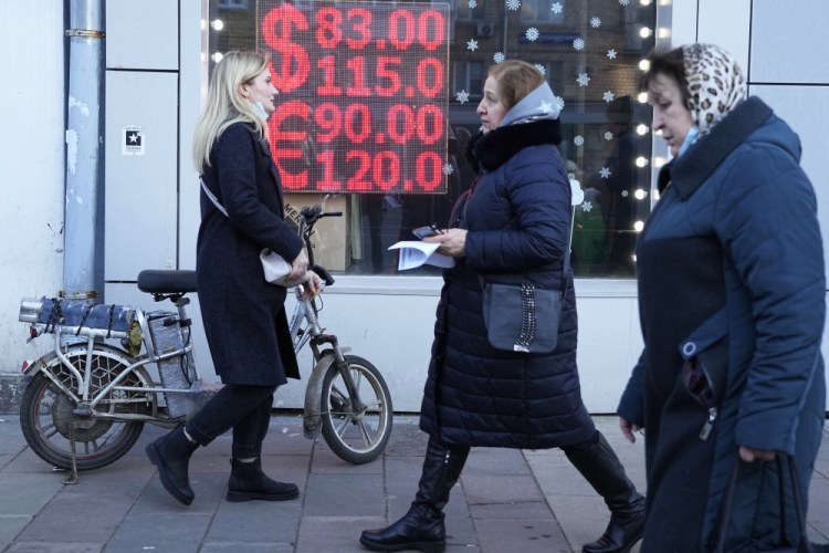 People walk past a currency exchange office in Moscow on Feb. 28. The full impact of Western sanctions is starting to be felt in very real ways.