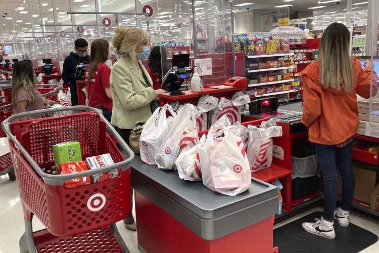 A customer wears a mask as she waits to get a receipt at a register in a Target store in Vernon Hills, Ill., in May 2021.  