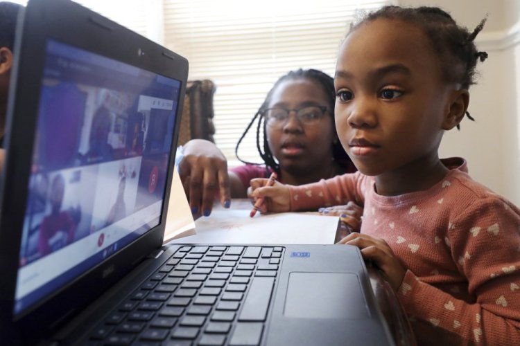 Lear Preston, 4, participates in her virtual classes as her mother, Brittany Preston, helps at their home in Chicago on Feb. 10, 2021.