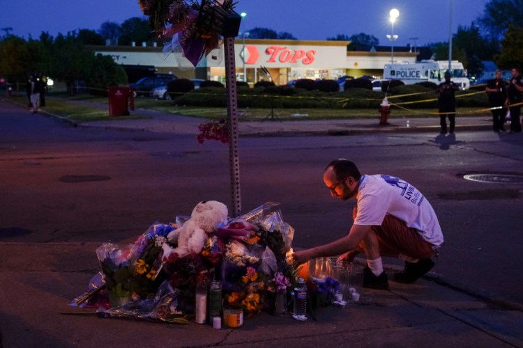 A man pays his respects May 15 at a makeshift memorial outside the scene of a shooting at a supermarket in Buffalo, N.Y.
