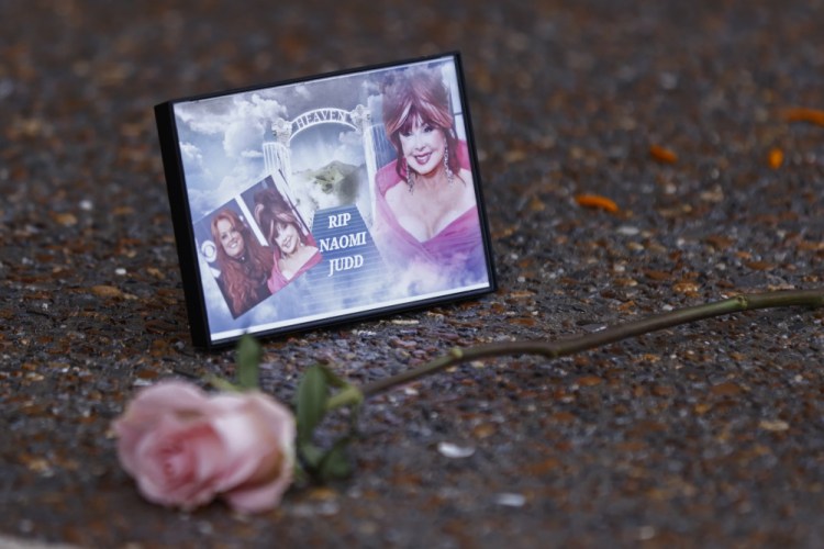 A photograph of Naomi Judd lays with a rose outside the Country Music Hall of Fame before the medallion ceremony on Sunday in Nashville, Tenn.