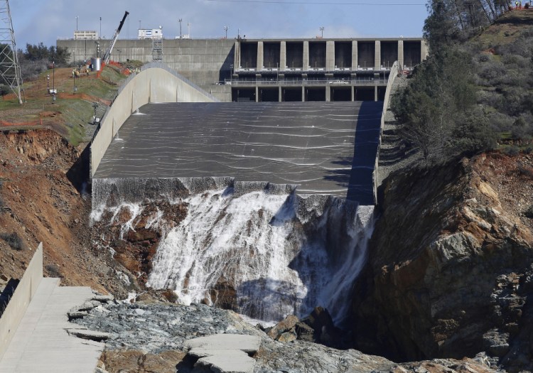 Water flows down the Oroville Dam's crippled spillway in Oroville, Calif., on Feb. 28, 2017. Americans wondering whether a nearby dam could be dangerous can look up the condition and hazard ratings of tens of thousands of dams nationwide using an online database run by the federal government. But they won't find the condition of Oroville Dam, which underwent a $1 billion makeover after its spillway failed. 