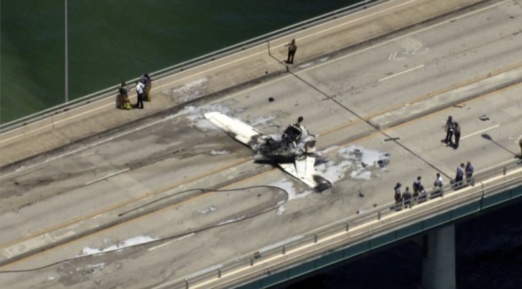 Emergency personnel respond to a small plane crash on a Miami bridge on Saturday. The plane struck an SUV and burst into flames. Six people were reported injured. (WSVN-TV via AP)