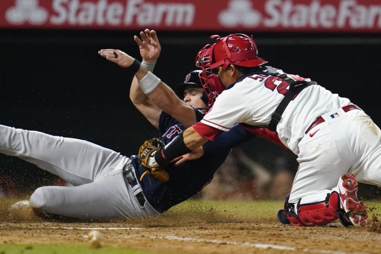 Boston Red Sox's Bobby Dalbec is out at home after a tag from Los Angeles Angels catcher Kurt Suzuki (24) on Wednesday in Anaheim.