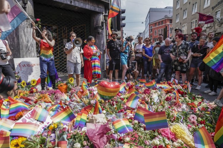 Flowers are left as a spontaneous pride parade arrives at the scene of a shooting in central Oslo, Saturday, June 25. Norwegian police say they are investigating an overnight shooting in Oslo that killed two people and injured more than a dozen as a case of possible terrorism. 