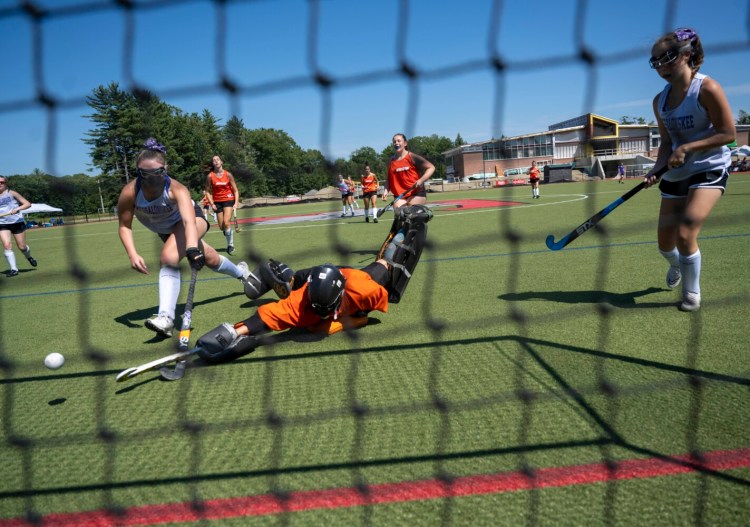 Winslow goalie Laine Bell (22) makes a save against Messalonskee at the Victories Over Violence field hockey tournament earlier this summer at Thomas College in Waterville.