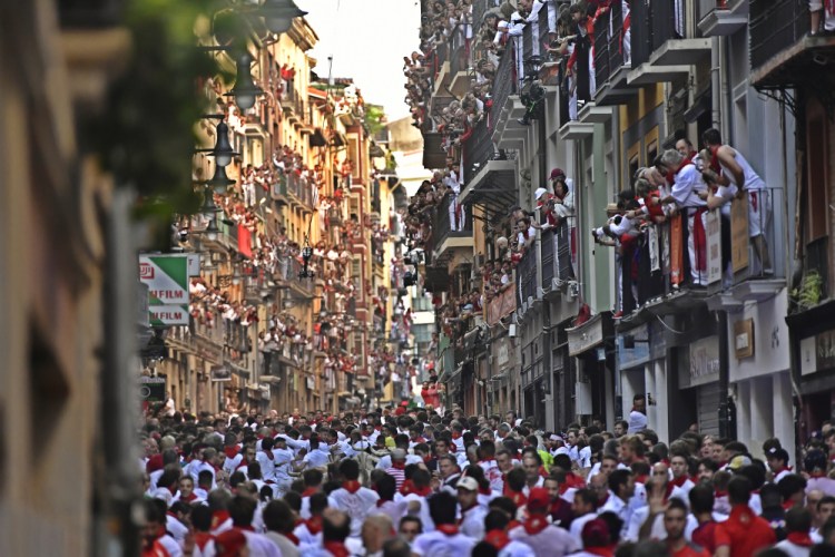 People run through the streets ahead of the bulls on the first day of the San Fermin Festival in Pamplona on Spain, Thursday.