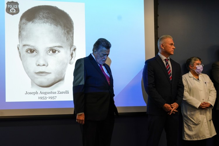 William C. Fleisher, with the Vidocq Society, center, Philadelphia Police Captain Jason Smith, and Dr. Constance DiAngelo, Philadelphia chief medical examiner, listen in front of a picture of the newly identified "Boy in the Box" during a news conference on Thursday in Philadelphia.