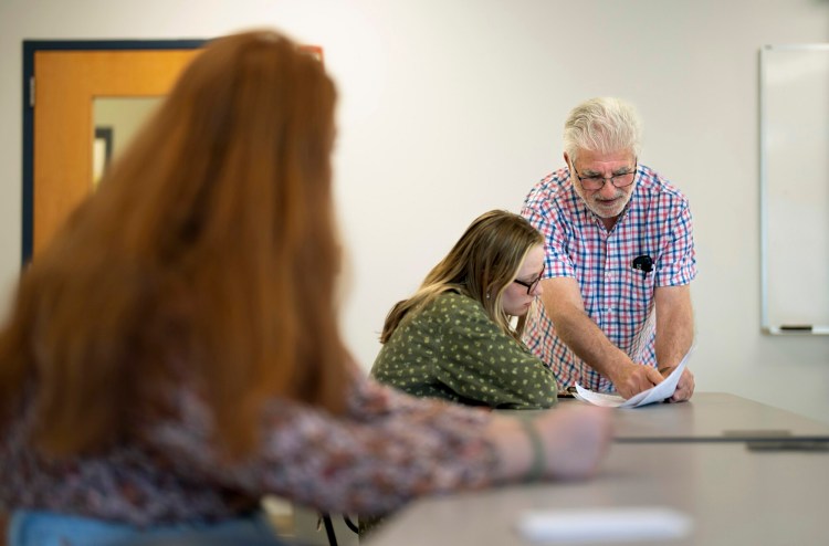 Adjunct professor Richard Rottkov goes over an assignment with Elizabeth Cloutier during an oral communication class at Southern Maine Community College in South Portland. Maine Community College System adjunct professors are in contract negotiations and are fighting for pay closer to what full time professors are paid.