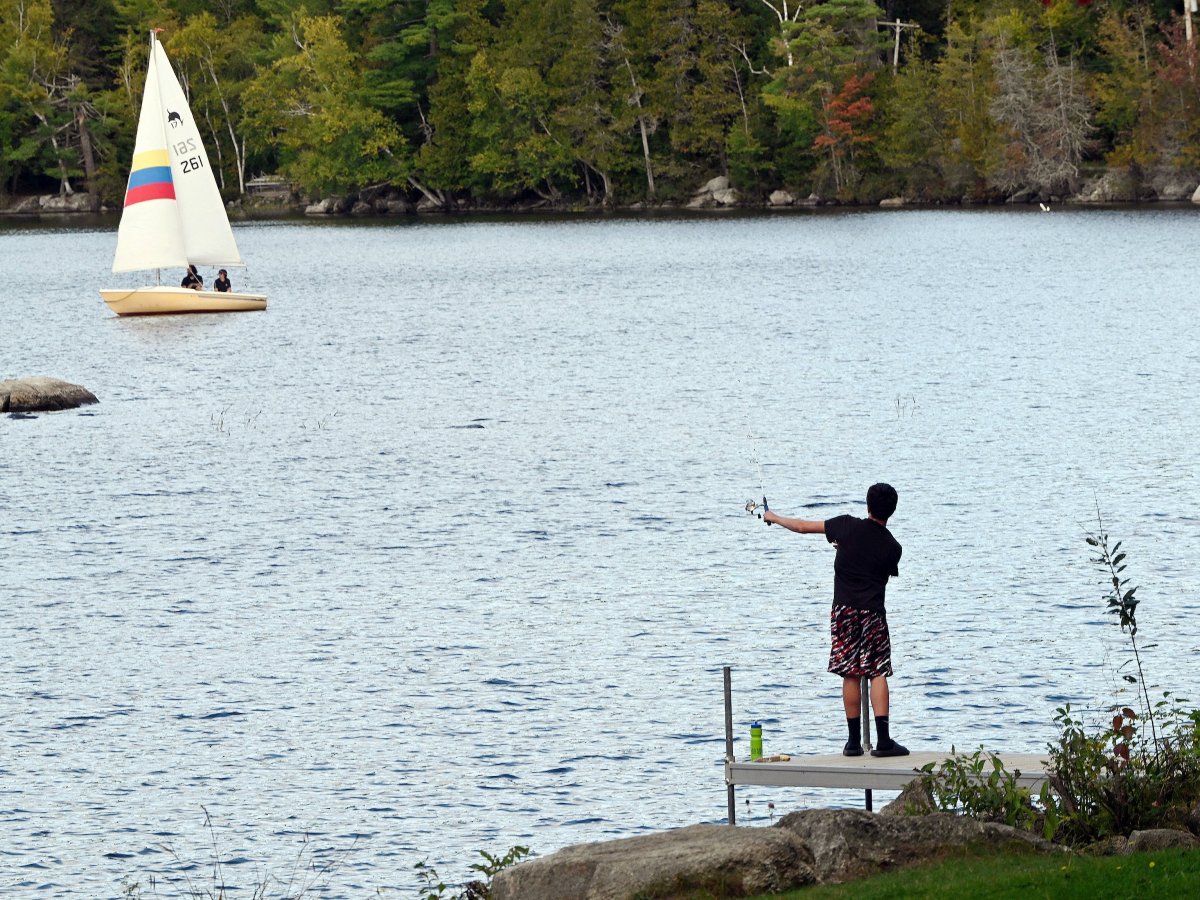 A fisherman and a couple boaters share the water Sunday at Lake George Regional West in Skowhegan.