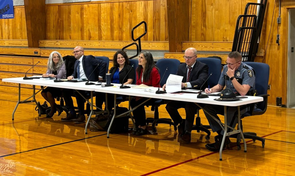officials sit in gym